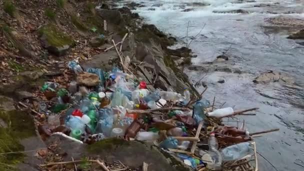 彫刻されていない人々はゴミを川に投げ込み 速い水はポリエチレンやその他の非分解性の文明廃棄物を大きな川に運び込み 銀行をプラスチックで散らす — ストック動画