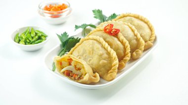 Pastel Goreng olarak bilinen Endonezya 'daki kızarmış pasteller. Kızarmış hamur işi, sebze, tavuk ve haşlanmış yumurtayla birlikte beyaz arka planda çiğ biberle servis ediliyor. Kapat.