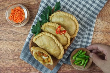 Pastel Goreng olarak bilinen Endonezya 'daki kızarmış pasteller. Elle ahşap bir tabakta çiğ biberle servis edilen sebze, tavuk ve haşlanmış yumurtayla dolu kızarmış hamur işi. Üst görünüm