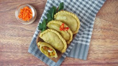 Pastel Goreng olarak bilinen Endonezya 'daki kızarmış pasteller. Elle ahşap bir tabakta çiğ biberle servis edilen sebze, tavuk ve haşlanmış yumurtayla dolu kızarmış hamur işi. Üst görünüm