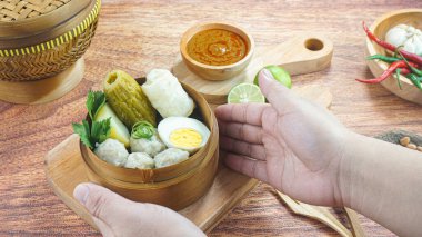 Balık köftesi veya Siomay, Endonezya 'da patates yumurtalı lahana rulosu fıstıklı biberli limondan yapılan ve bambu kasesinde elle servis edilen geleneksel bir yemektir. Kapat.