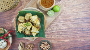 Kızarmış bakso ve tofu ya da Batagor, Endonezya 'nın geleneksel bir yiyeceğidir. Kara ahşap arka planda servis edilen baharatlı fındık soslu balık tapyokası çeşnisinden yapılmıştır.