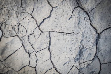 Cracked earth in the top view for the background or graphic design with the concept of drought and death.