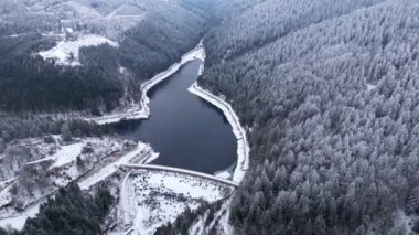 Ormandaki dağların panoramik kış drone görüntüsü. Sinema kışı karlı ormanı. Karla kaplı ormanlar. Sinema banliyösü manzarası.