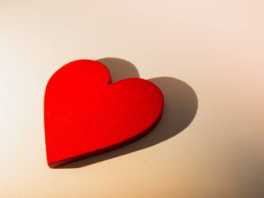 Valentine's Day. Red wooden heart concept on light background with heart shadow