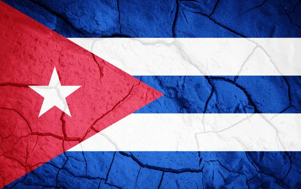 Flag of Cuba. Cuba symbol. Flag on the background of dry cracked earth. Cuba flag with drought concept