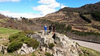 Metalden yapılmış çocuğu olan bir keçi heykeli. Col de l 'Escrinet dağının eteğinde. Genç bir kadın Col de l 'Escrinet ambleminin dibinde heykelin yanında fotoğraf çekiyor..
