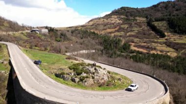 Metalden yapılmış çocuğu olan bir keçi heykeli. Col de l 'Escrinet dağının eteğinde. Genç bir kadın Col de l 'Escrinet ambleminin dibinde heykelin yanında fotoğraf çekiyor..