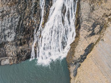 Fransız Alplerinde Lac Chambon 'a akan bir şelalenin panoramik drone görüntüsü