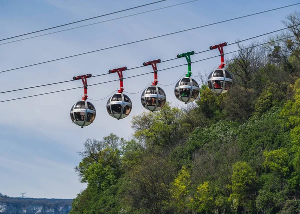 Mavi gökyüzüne karşı gondol kabarcıkları. Fransa 'nın Grenoble kentindeki Fort de La Bastille' e turist taşıyan teleferik.