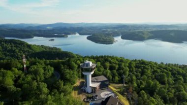 Günbatımında İHA 'nın panoramik görüntüsü Soliskie Gölü' nde Solina su barajının üstündeki gözetleme kulesine bakan modern teleferik vagonu Polonya 'nın Bieszczady Dağları' nda.