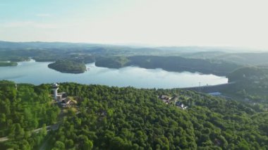 Günbatımında İHA 'nın panoramik görüntüsü Soliskie Gölü' nde Solina su barajının üstündeki gözetleme kulesine bakan modern teleferik vagonu Polonya 'nın Bieszczady Dağları' nda.