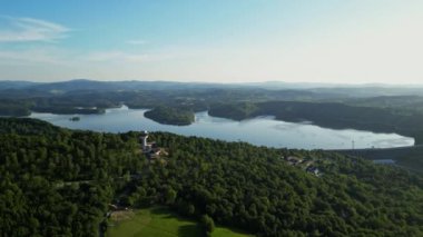 Günbatımında İHA 'nın panoramik görüntüsü Soliskie Gölü' nde Solina su barajının üstündeki gözetleme kulesine bakan modern teleferik vagonu Polonya 'nın Bieszczady Dağları' nda.