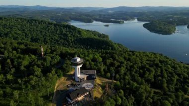 Günbatımında İHA 'nın panoramik görüntüsü Soliskie Gölü' nde Solina su barajının üstündeki gözetleme kulesine bakan modern teleferik vagonu Polonya 'nın Bieszczady Dağları' nda.