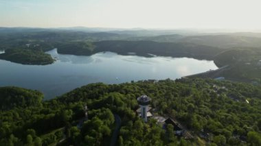 Günbatımında İHA 'nın panoramik görüntüsü Soliskie Gölü' nde Solina su barajının üstündeki gözetleme kulesine bakan modern teleferik vagonu Polonya 'nın Bieszczady Dağları' nda.