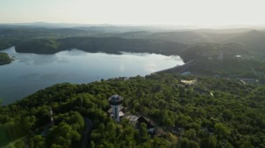 Günbatımında İHA 'nın panoramik görüntüsü Soliskie Gölü' nde Solina su barajının üstündeki gözetleme kulesine bakan modern teleferik vagonu Polonya 'nın Bieszczady Dağları' nda.