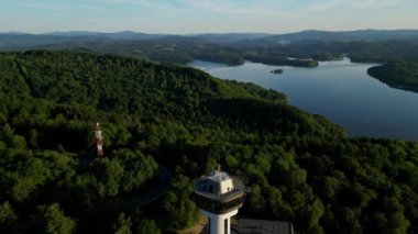 Günbatımında İHA 'nın panoramik görüntüsü Soliskie Gölü' nde Solina su barajının üstündeki gözetleme kulesine bakan modern teleferik vagonu Polonya 'nın Bieszczady Dağları' nda.