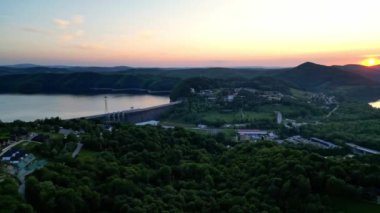 Günbatımında İHA 'nın panoramik görüntüsü Soliskie Gölü' nde Solina su barajının üstündeki gözetleme kulesine bakan modern teleferik vagonu Polonya 'nın Bieszczady Dağları' nda.