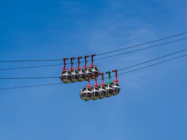 Mavi gökyüzüne karşı gondol kabarcıkları. Fransa 'nın Grenoble kentindeki Fort de La Bastille' e turist taşıyan teleferik.