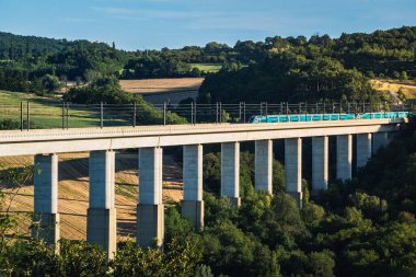 Grane, Fransa - 4 Ağustos 2023: Demiryolu üstgeçidini geçen yolcu treninin panoramik görüntüsü. Güney Fransa 'daki dağlara tepeden bakan
