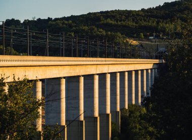 Grane, Fransa - 4 Ağustos 2023: Demiryolu üstgeçidini geçen yolcu treninin panoramik görüntüsü. Güney Fransa 'daki dağlara tepeden bakan