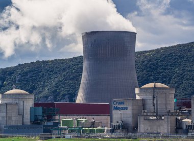 Cruas, Fransa - 4 Nisan 2023: Nükleer santral (CNPE Cruas-Meysse) üzerindeki nehir üzerinde arka plandaki kireçtaşı kayalarına bakın.