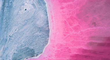 Pembe tuz gölünün havadan görünüşü. Tuz üretim tesisleri tuz gölündeki tuzlu su birikintisini buharlaştırdı. Güney Fransa, Provence 'deki Camargue' de Salin de Giraud tuz fabrikası.