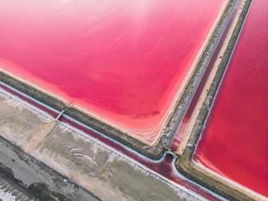 Pembe tuz gölünün havadan görünüşü. Tuz üretim tesisleri tuz gölündeki tuzlu su birikintisini buharlaştırdı. Güney Fransa, Provence 'deki Camargue' de Salin de Giraud tuz fabrikası.