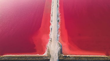 Pembe tuz gölünün havadan görünüşü. Tuz üretim tesisleri tuz gölündeki tuzlu su birikintisini buharlaştırdı. Güney Fransa, Provence 'deki Camargue' de Salin de Giraud tuz fabrikası.