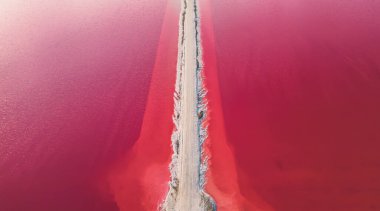 Pembe tuz gölünün havadan görünüşü. Tuz üretim tesisleri tuz gölündeki tuzlu su birikintisini buharlaştırdı. Güney Fransa, Provence 'deki Camargue' de Salin de Giraud tuz fabrikası.