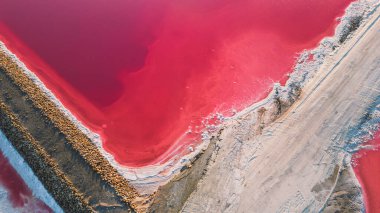 Pembe tuz gölünün havadan görünüşü. Tuz üretim tesisleri tuz gölündeki tuzlu su birikintisini buharlaştırdı. Güney Fransa, Provence 'deki Camargue' de Salin de Giraud tuz fabrikası.