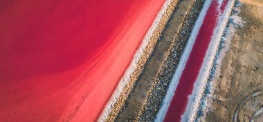 Pembe tuz gölünün havadan görünüşü. Tuz üretim tesisleri tuz gölündeki tuzlu su birikintisini buharlaştırdı. Güney Fransa, Provence 'deki Camargue' de Salin de Giraud tuz fabrikası.