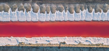 Pembe tuz gölünün havadan görünüşü. Tuz üretim tesisleri tuz gölündeki tuzlu su birikintisini buharlaştırdı. Güney Fransa, Provence 'deki Camargue' de Salin de Giraud tuz fabrikası.