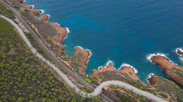 Massif de L 'Esterel' in hava manzarası ve Akdeniz 'e düşen uçurumların üzerinde güzel bir viraj yolu. Fransız Rivierası. Cote d'Azur