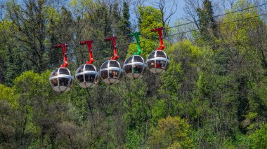 Masmavi gökyüzüne karşı gondol kabarcıkları ve arka planda Fransız Alpleri. Fransa 'nın Grenoble kentindeki Fort de La Bastille' e turist taşıyan teleferik.