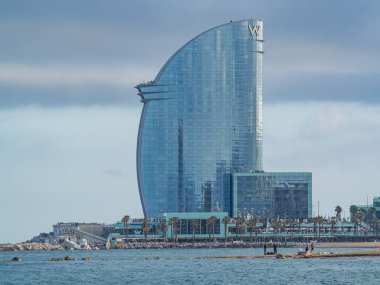 Barselona, İspanya - 5 Mayıs 2023: Lüks 5 yıldızlı W Barselona Oteli ünlü Barceloneta Boardwalk kıyısında yer almaktadır., 
