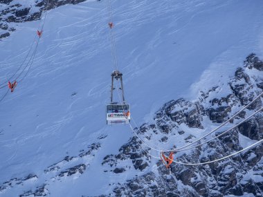 Les Diablerets, İsviçre - 15 Mart 2025: Buzul 3000 zirvesine yolcu taşıyan dağ teleferiği, dünyanın İsviçre Alpleri 'ndeki iki tepe arasındaki tek metal köprüsüne sahip panoramik manzaraya sahip.