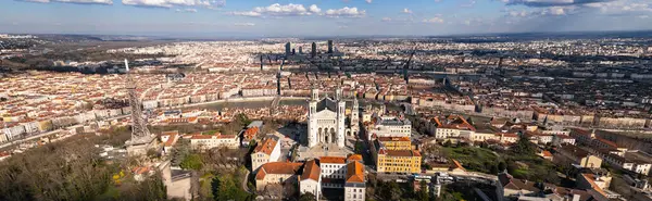 Fransa 'nın Lyon kentindeki Fourvire Hill' deki Notre-Dame de Fourvire Bazilikası 'nın hava panoramik görüntüsü, açık güneşli bir günde arka planda şehir manzarası ve metalik kule.