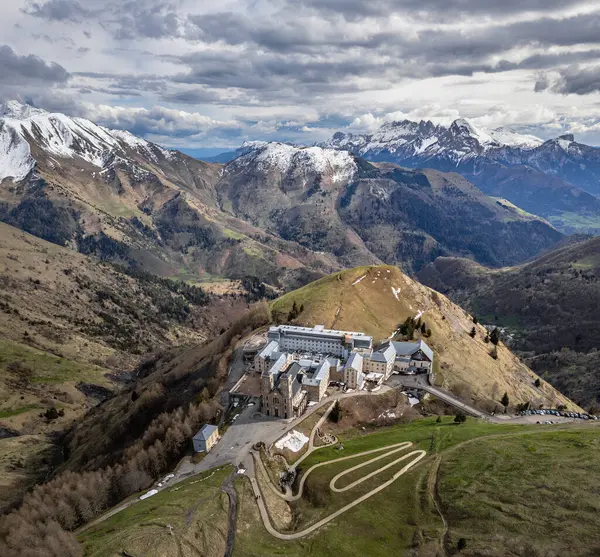 La Salette Sığınağı 'nın panoramik manzarası güneş ışığıyla yıkanmış, arka planda karla kaplı dağ zirveleri ve huzurlu bir dağlık arazi.