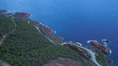 Massif de L 'Esterel' in hava manzarası ve Akdeniz 'e düşen uçurumların üzerinde güzel bir viraj yolu. Fransız Rivierası. Cote d'Azur