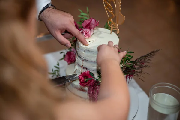 婚礼接待处的新娘和新郎在一家用鲜花切婚礼蛋糕的餐厅里 高质量的照片 — 图库照片