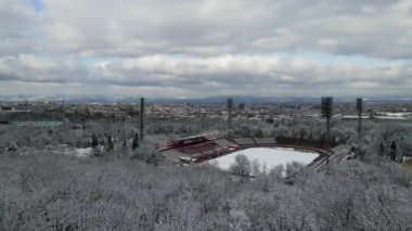 Bir kar ormanının ve Bulgaristan 'ın Sofya kentindeki stadyumun insansız hava aracı görüntüleri. Şehirdeki binalar. Yüksek kalite 4k görüntü