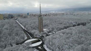 Sofya 'nın merkezindeki bir parktaki televizyon iletim kulesi. Kara ve ağaçlar karla kaplı. Hava aracı görüntüleri. Yüksek kalite 4k görüntü