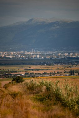 Bulgaristan 'da büyük bir dağın altındaki şehre bakan bir tarla. Güzel manzara fotoğrafçılığı. Yüksek kalite fotoğraf