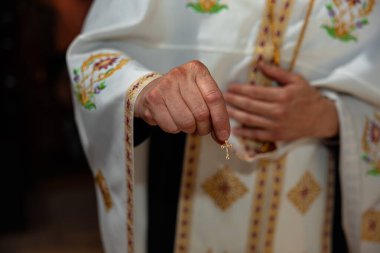 Bir bebeğin ortodoks vaftiz töreni sırasında elinde altın haç kolyesi olan bir rahip. Yüksek kalite fotoğraf