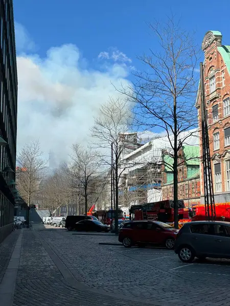 Stock image 16.04.2024 - Copenhagen, Denmark - Famous trade building on fire. Firefighters trying to extinguish flames. Famous Danish landmark building in ruins. Smoke and ashes up in the sky. High quality photo