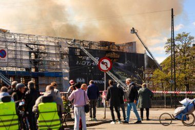 16.04.2024 Kopenhag, Danimarka ünlü ticaret binası yanıyor. İtfaiyeciler alevleri söndürmeye çalışıyor. Danimarka 'nın ünlü tarihi binası harabe halinde. Duman ve küller gökyüzüne yükseliyor. Yüksek kalite fotoğraf