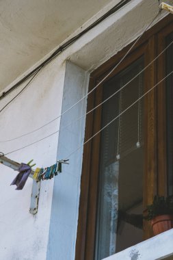 Balkondaki beyaz bir kablodan sarkan renkli ıslak bez mendil kurutma kıskacı. Yüksek kaliteli bir balkon fotoğrafı..