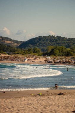 11 Ağustos 2023: Sozpol, Bulgaristan - Sozpol belediyesindeki güzel sahil kıyısı Arkutino. Suda yüzen insanlar. Uzak arka plandaki tepeler ve ormanlar. Yüksek kalite fotoğraf
