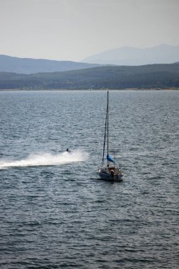 Iskar Reservoir Bulgaristan 'da bir yelkenli. Uzakta güzel Bulgar doğa dağları Suyu geçen bir jet gökyüzü. Yüksek kalite fotoğraf